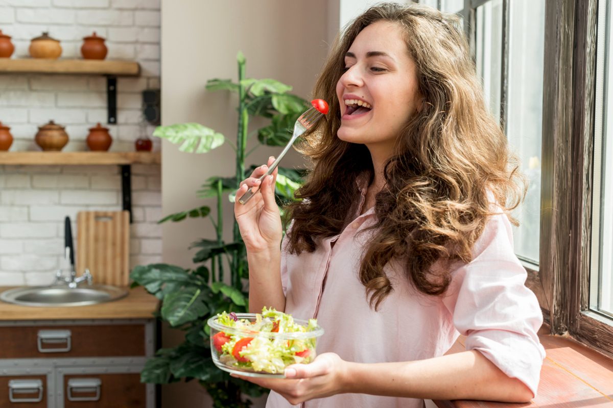 Woman enjoying a fresh, healthy salad at home